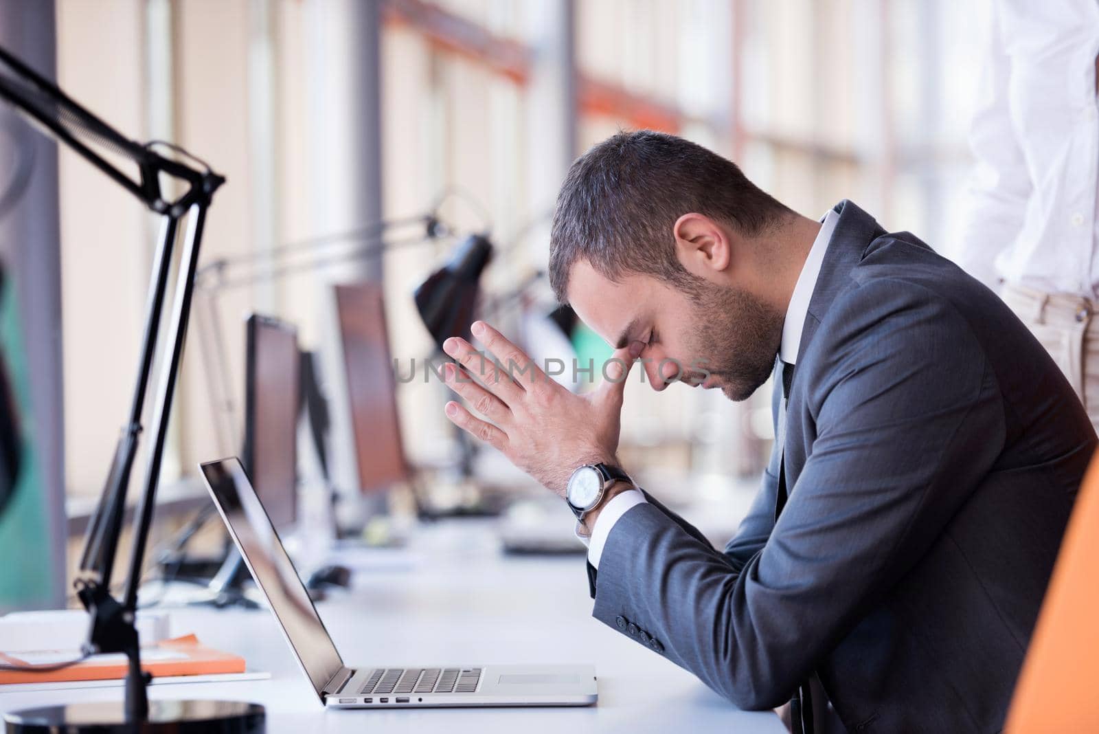 frustrated young business man working on laptop computer at office