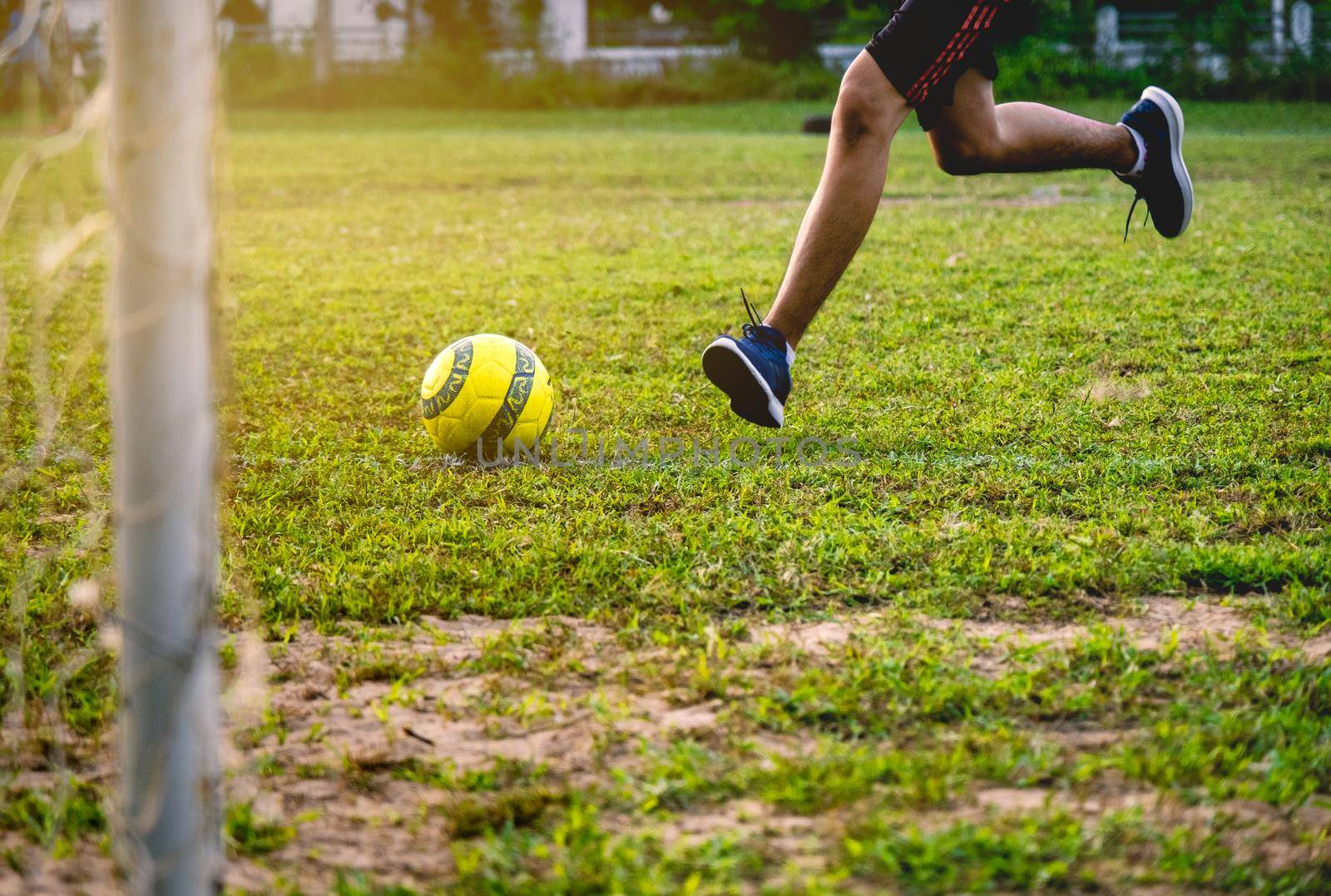 Football player training in soccer field. Young footballer practicing on football field.