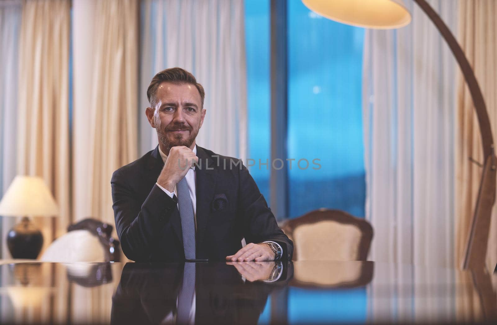 Senior executive businessman at luxury corporate workspace. Portrait of smiling ceo at modern office in stylish suit