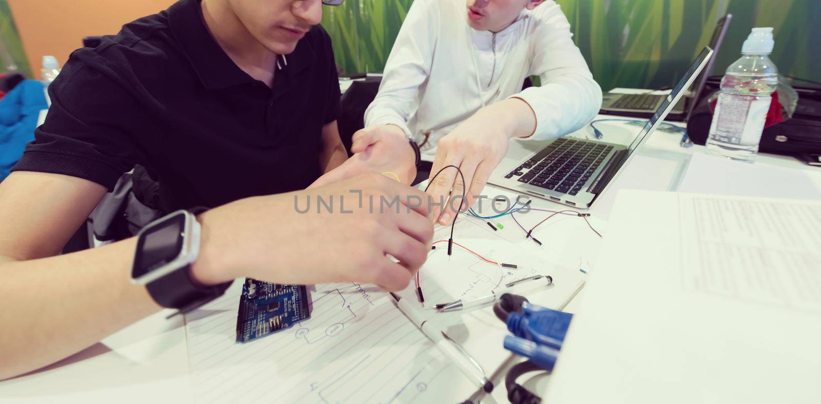 it students in computer science classroom  working together on project with mini pc hardware and code programming software on laptop