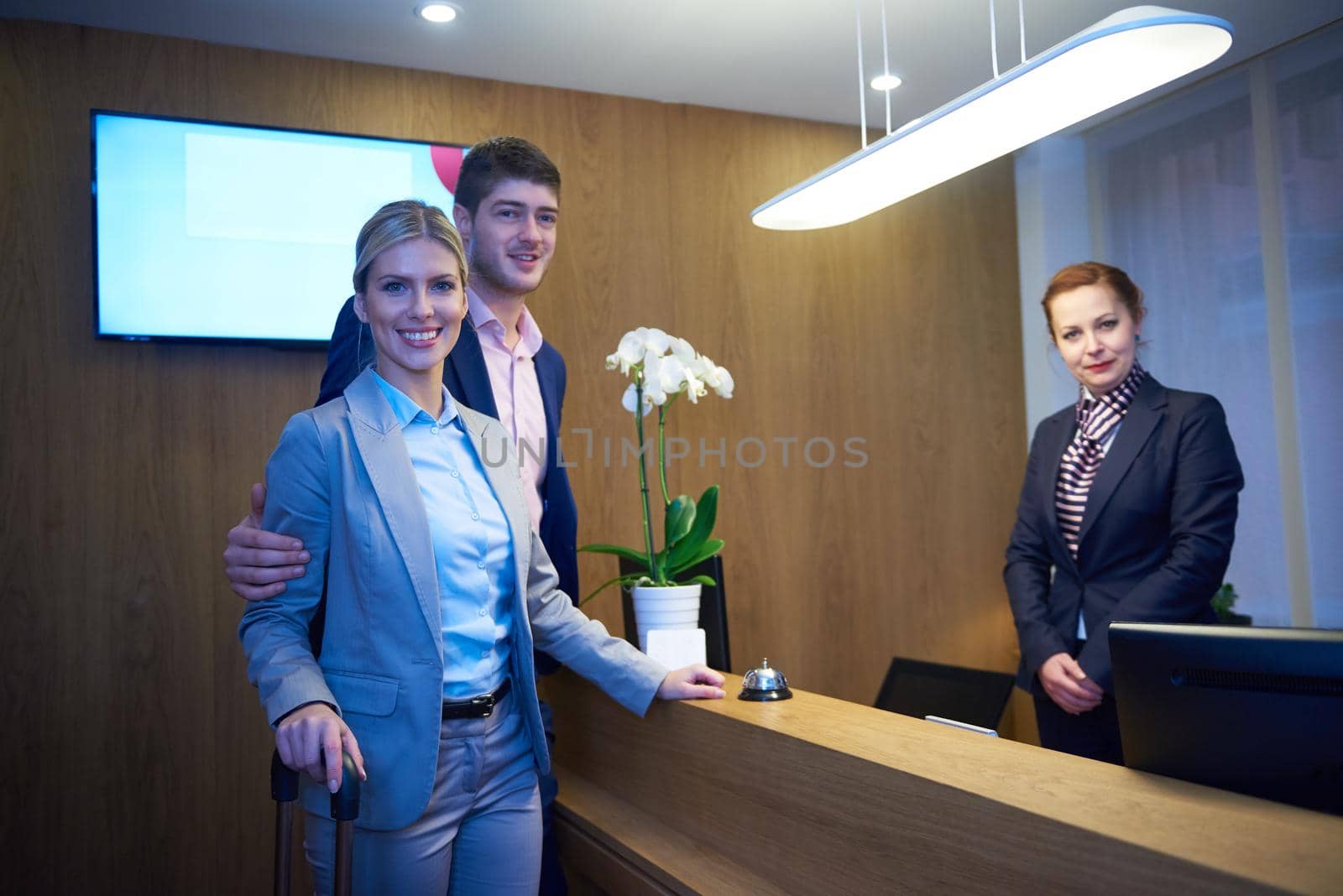 Couple on a business trip doing check-in at the hotel