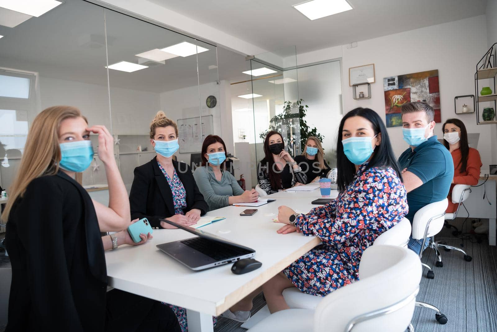 real businesspeople on business meeting in bright office on coronavirus new normal time wearing protective medical face mask and keep distance