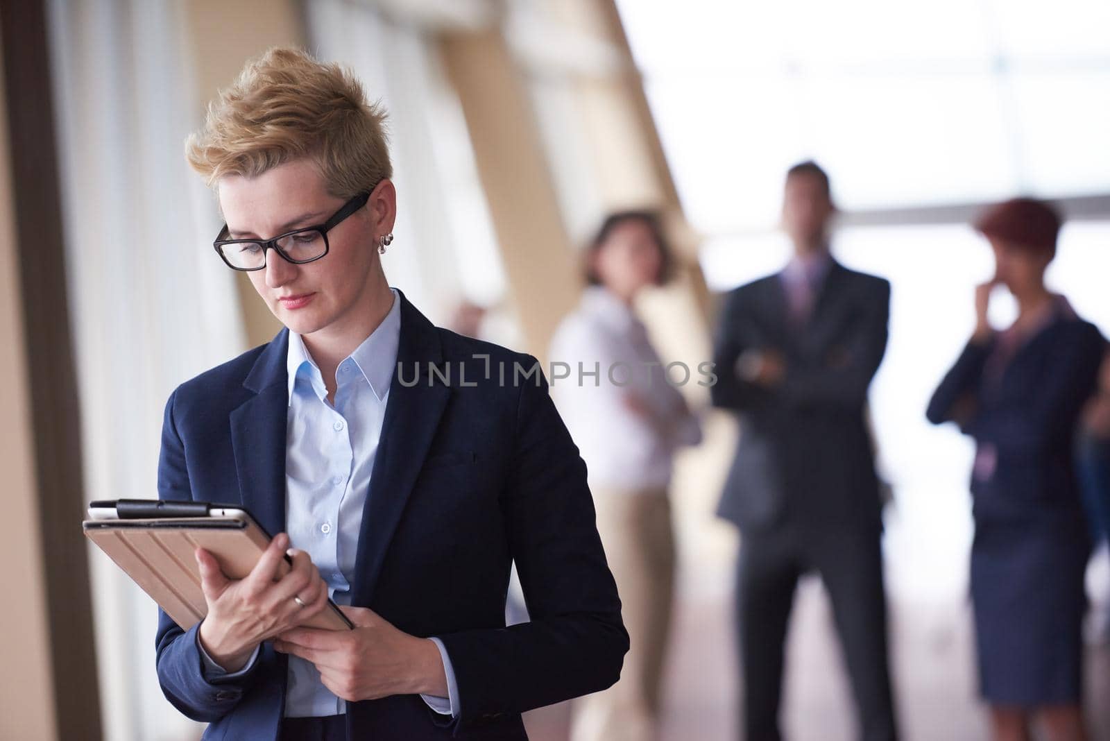 business woman  at office with tablet  in front  as team leader by dotshock