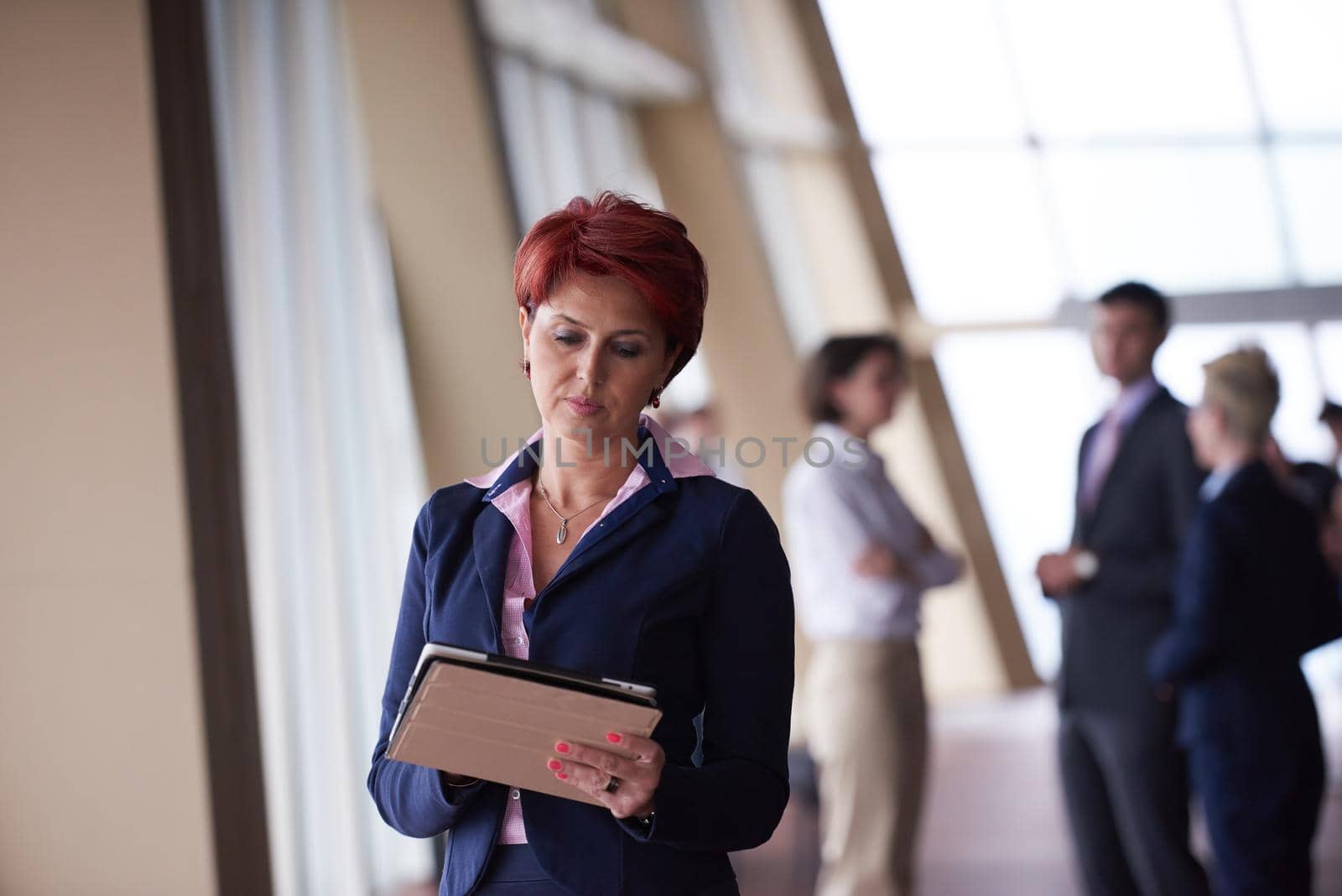 business woman  at office with tablet  in front  as team leader by dotshock