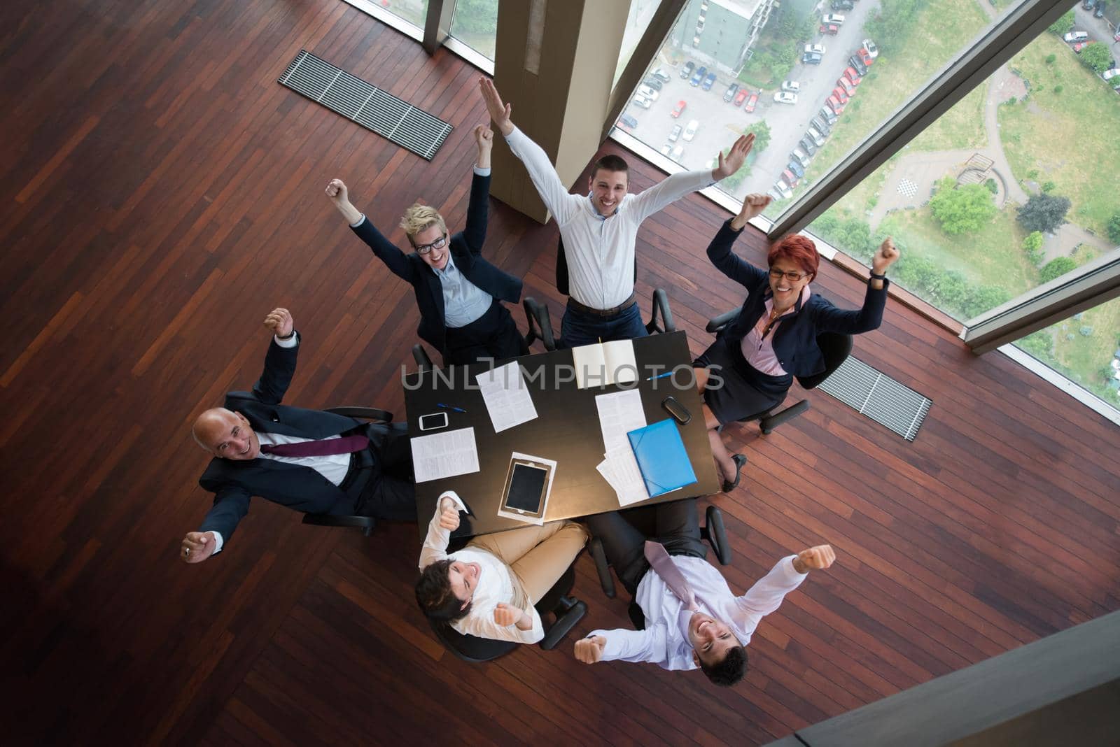 top view of happy  business people group on meeting throwing documents in air at modern office interior
