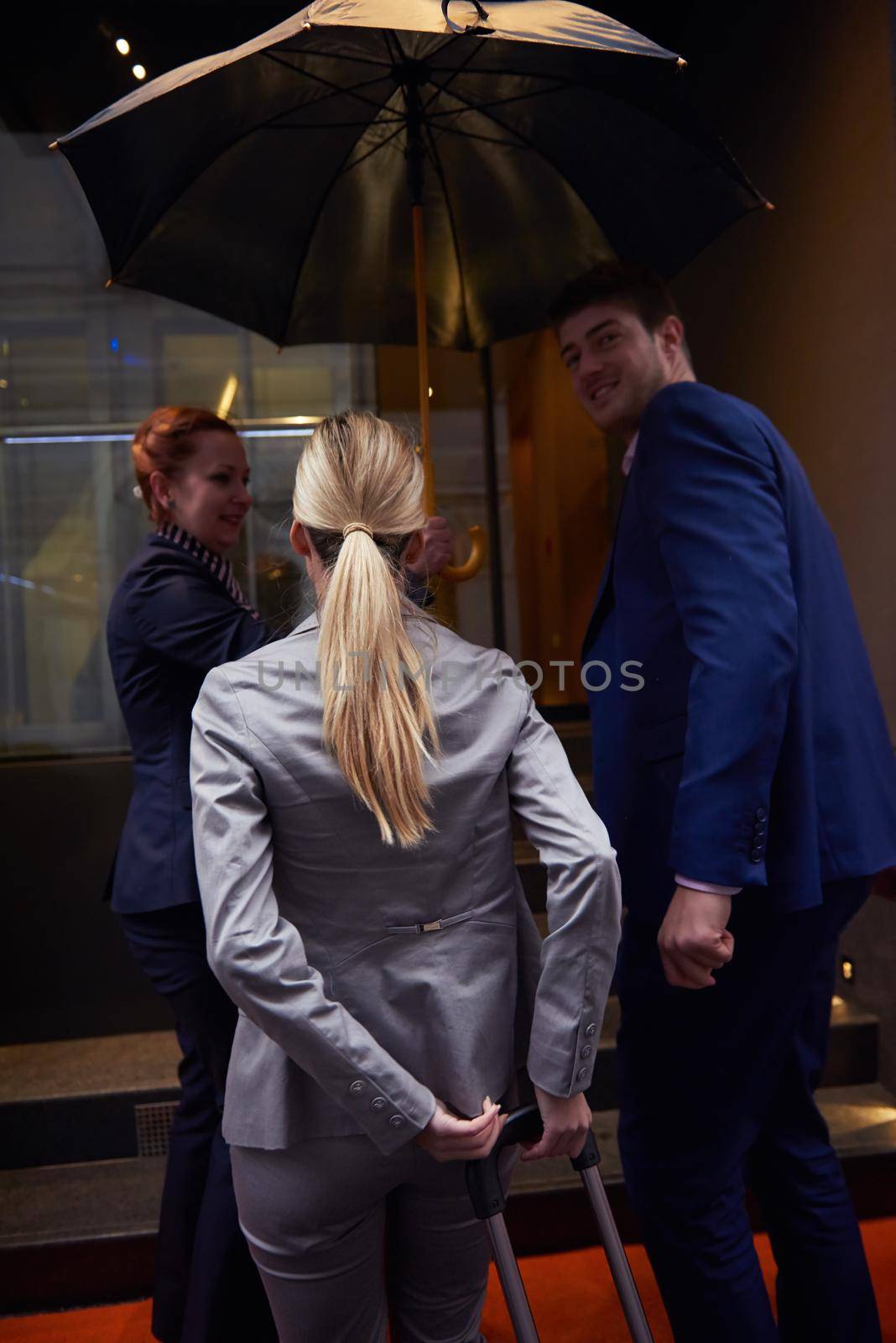 Young business people couple entering city  hotel, looking for room, holding suitcases while walking on street