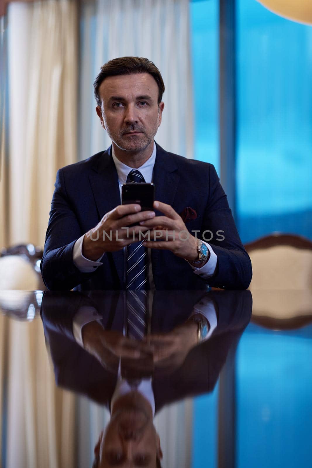 business man using smart phone at luxury office by dotshock