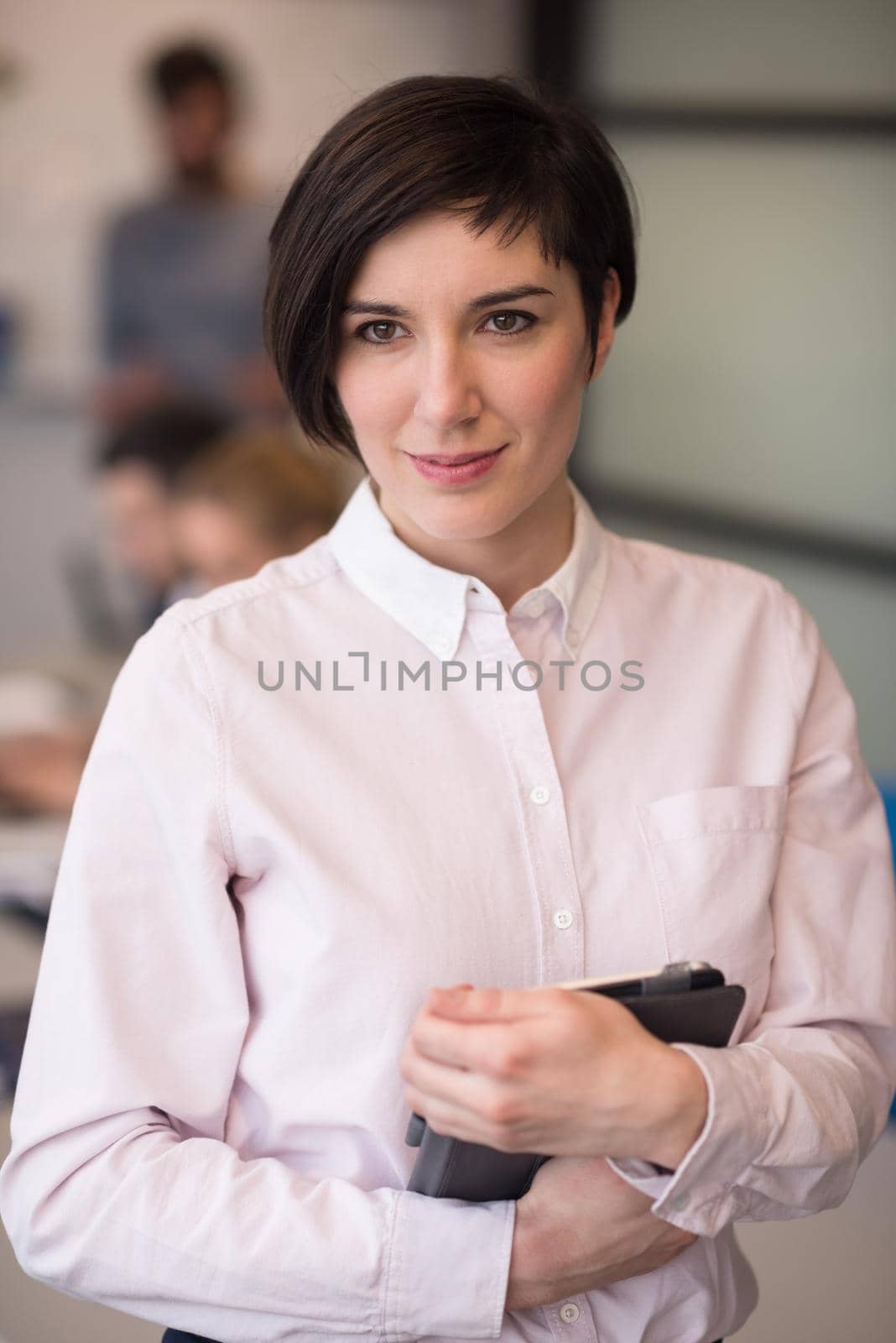 young hispanic businesswoman portrait with  tablet computer at modern startup business office interior, people group on team meeting blured in background