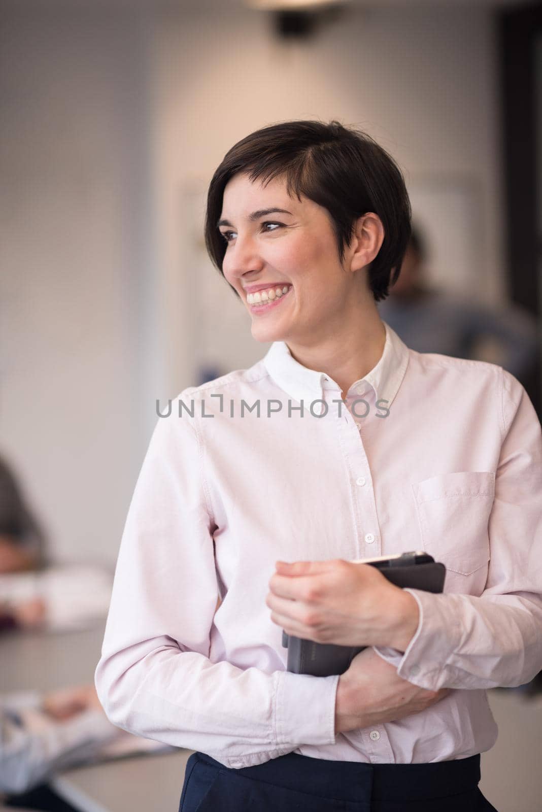 young hispanic businesswoman portrait with  tablet computer at modern startup business office interior, people group on team meeting blured in background