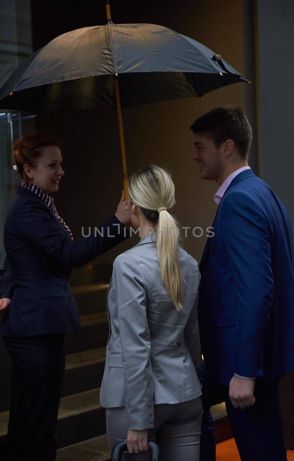 Young business people couple entering city  hotel, looking for room, holding suitcases while walking on street