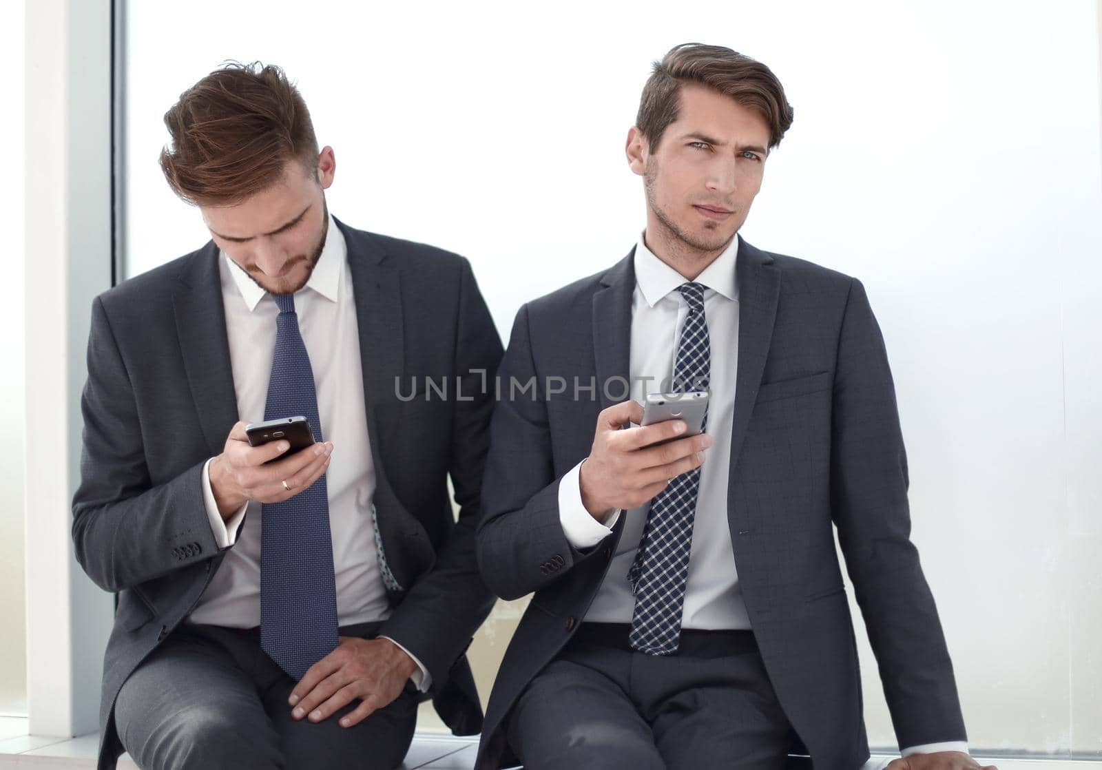 young employees using their smartphones during work break.office weekdays
