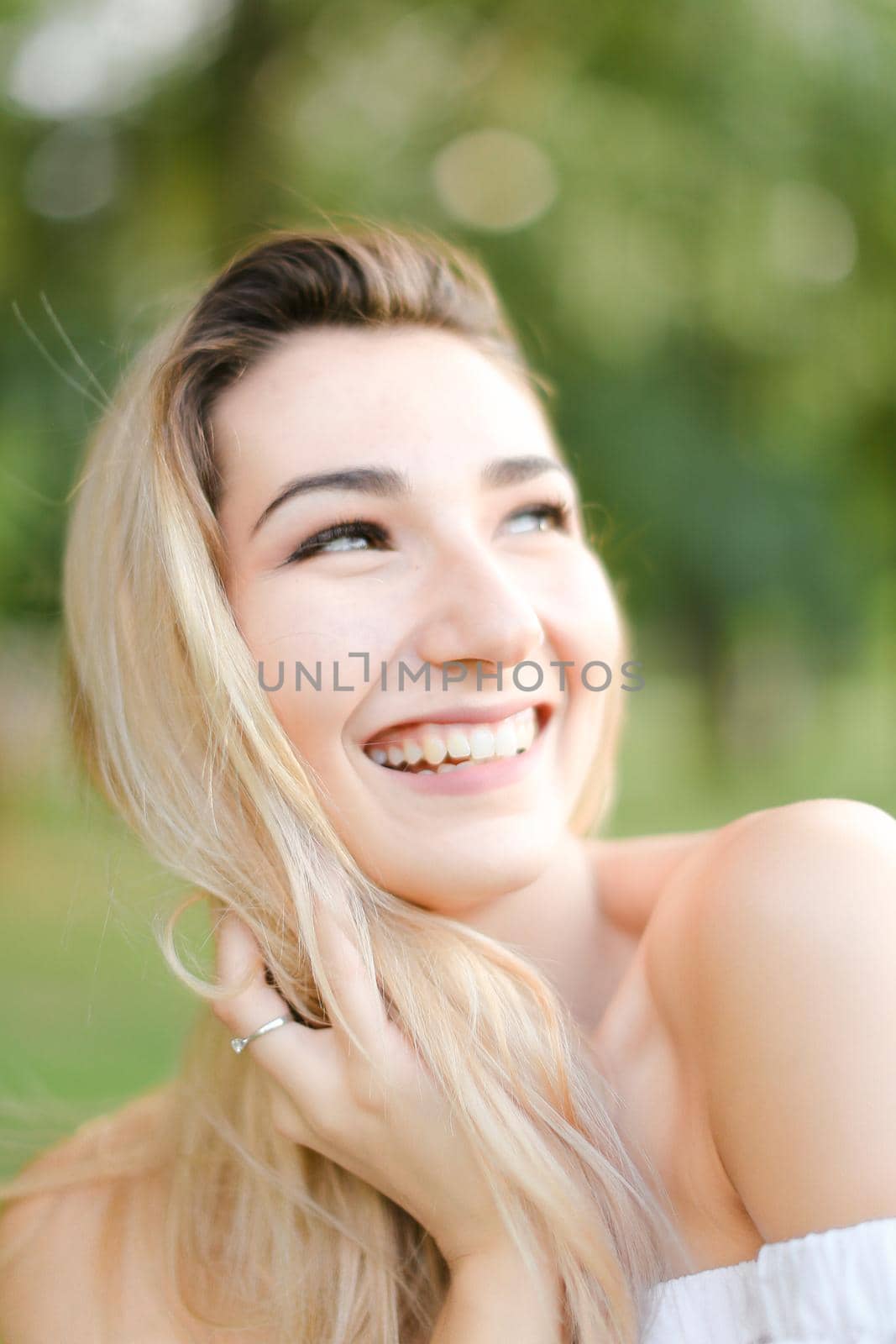 Portrait of young smiling girl, green background. Concept of beauty and everyday makeup.