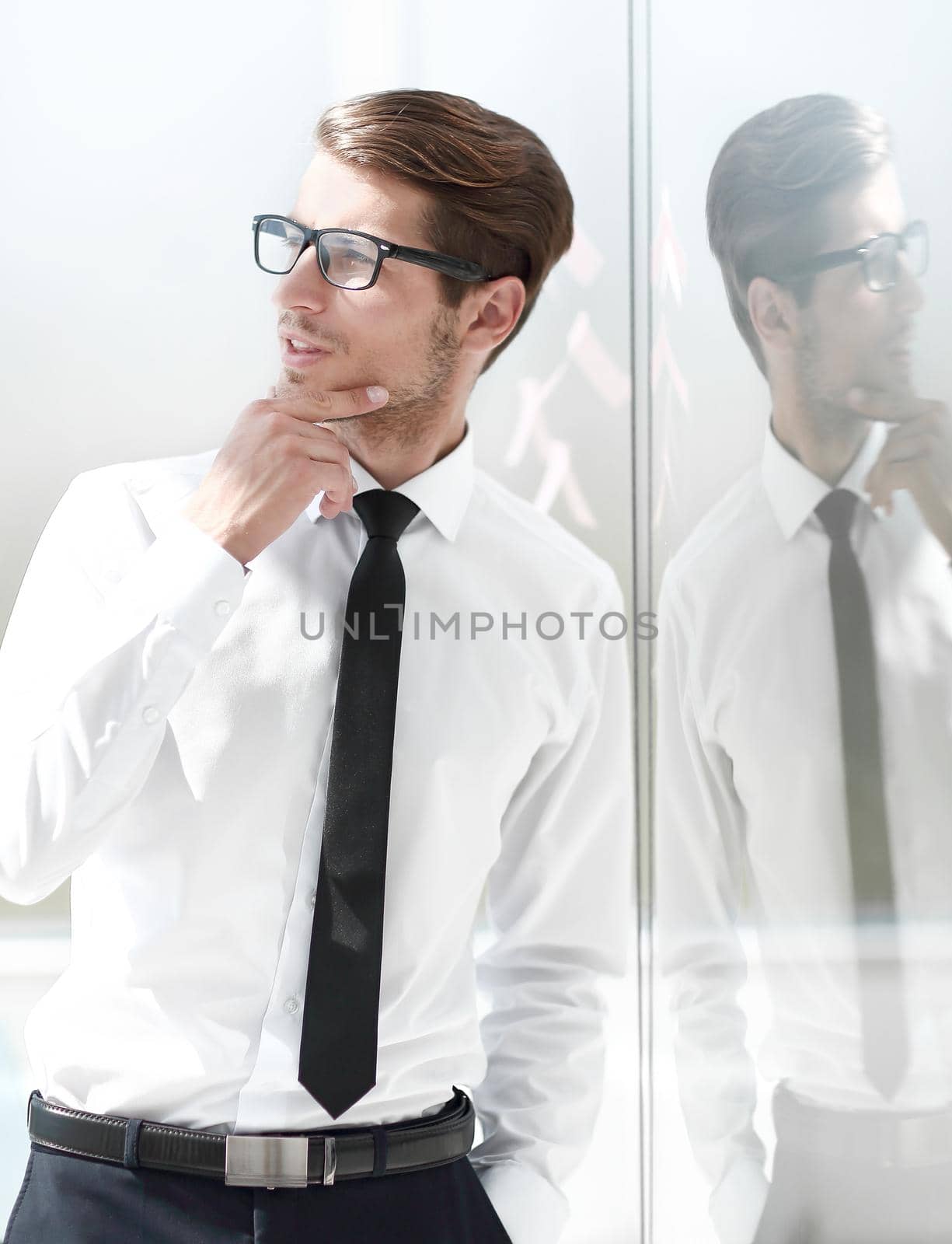 close up.pensive businessman standing in office. by asdf