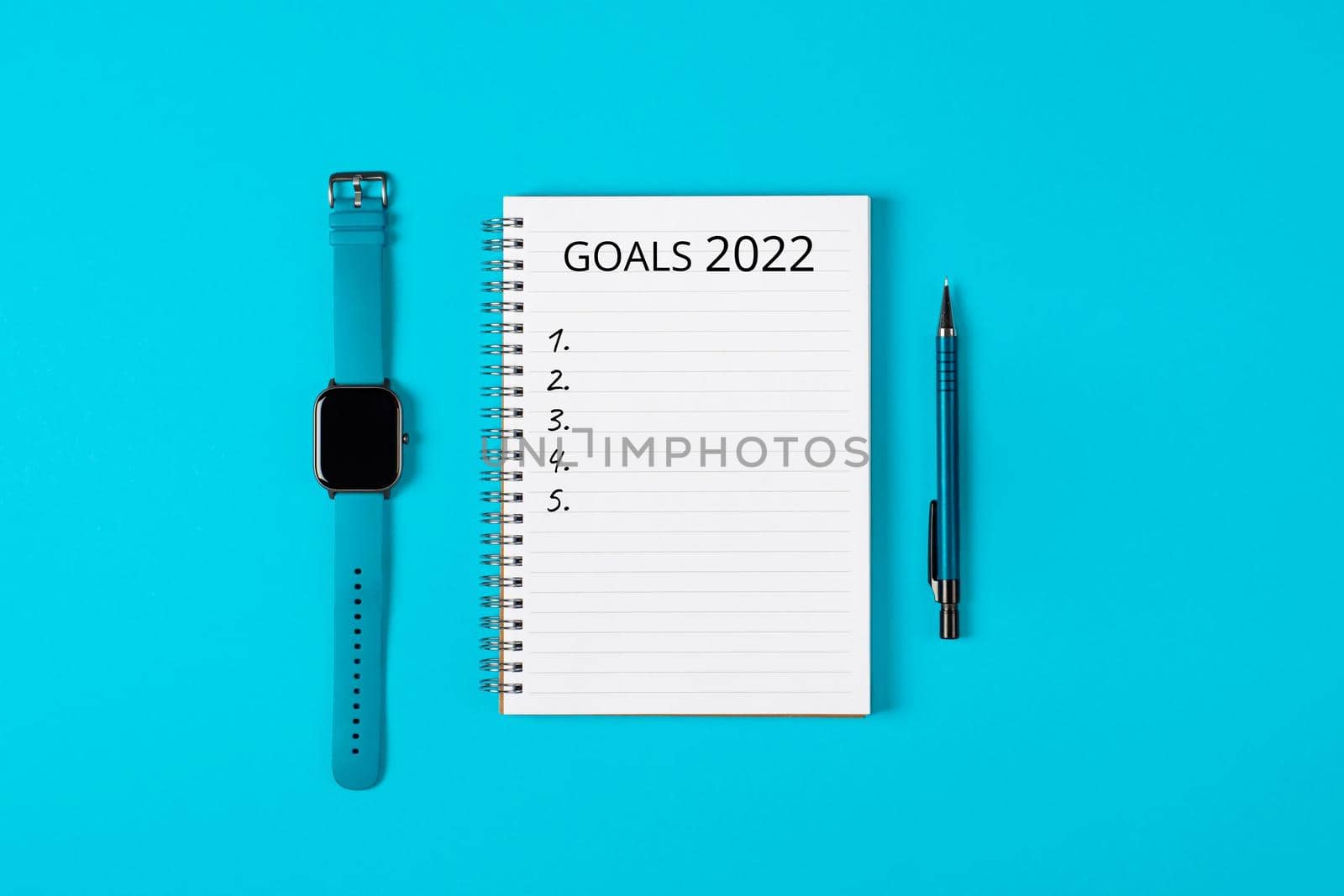 2022 goals concept banner. Notebook, pencil and watch isolated on blue background.