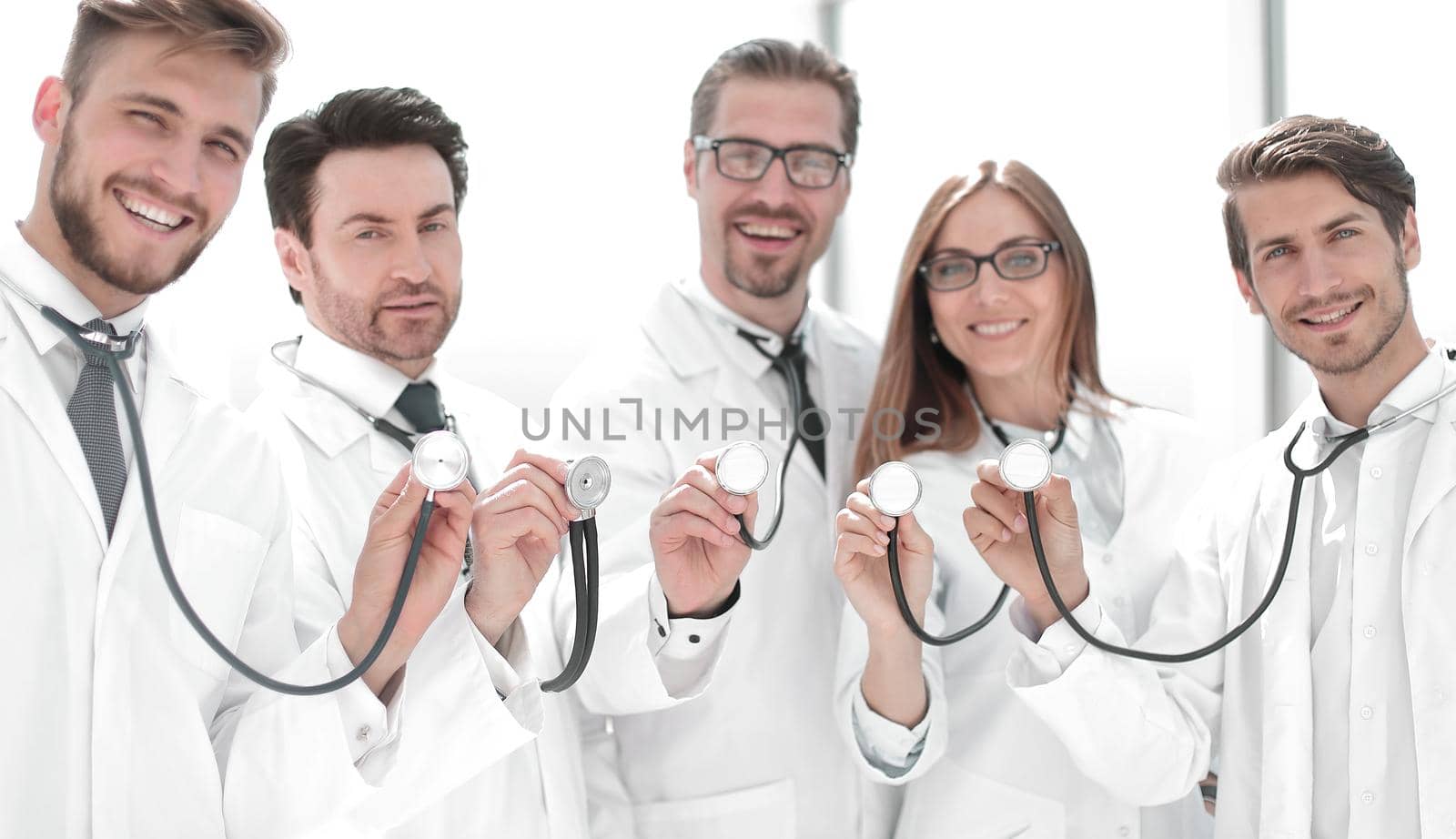 group of doctors hold their stethoscopes . the concept of professionalism
