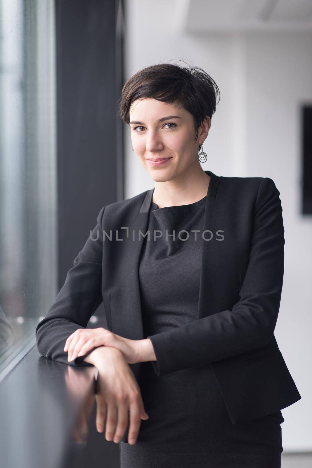 Portrait Of Successful Businesswoman by the window Entrepreneur At Busy startup Office