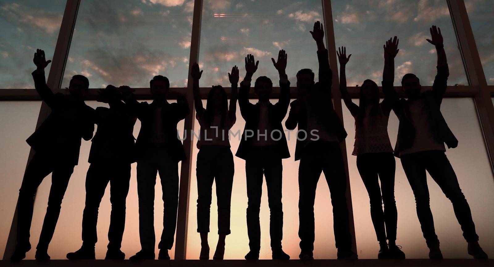 silhouette of a group of business people raising their hands .photo with copy space