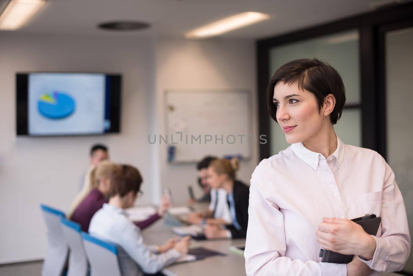 young hispanic businesswoman portrait with  tablet computer at modern startup business office interior, people group on team meeting blured in background
