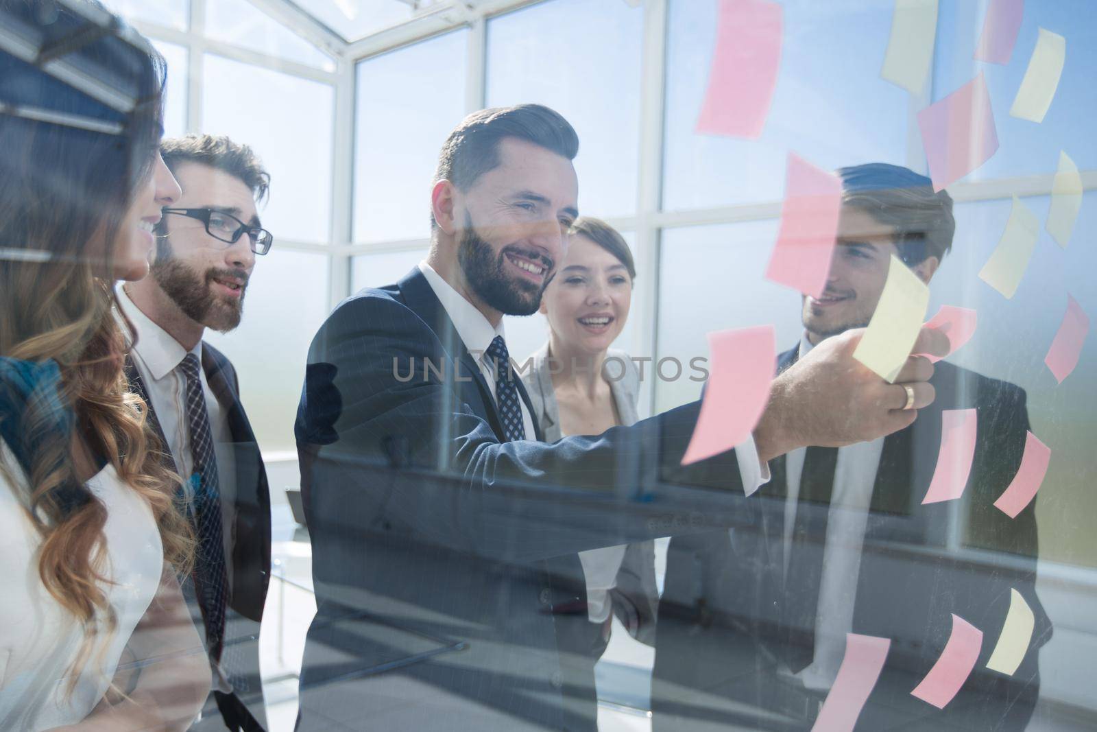 business team reading notes on glass.the concept of management