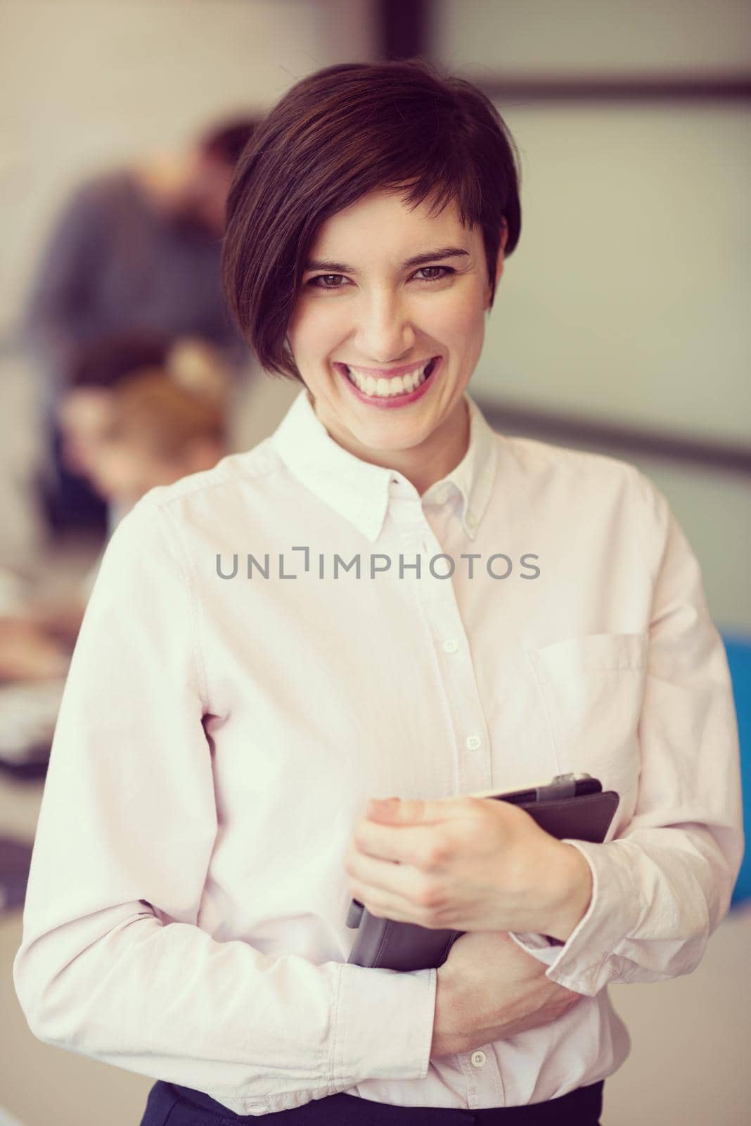 young hispanic businesswoman portrait with  tablet computer at modern startup business office interior, people group on team meeting blured in background