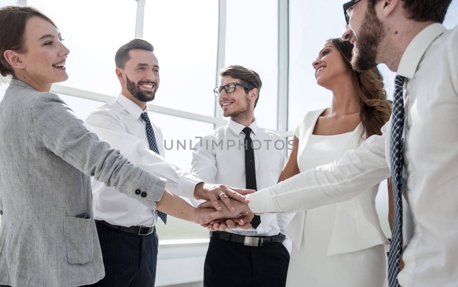 business team putting their hands together. the concept of unity