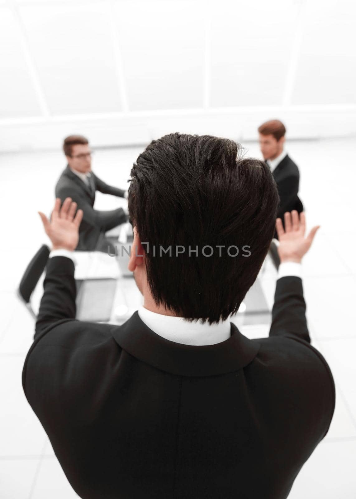 rear view.businessman refers to colleagues in the conference room by asdf