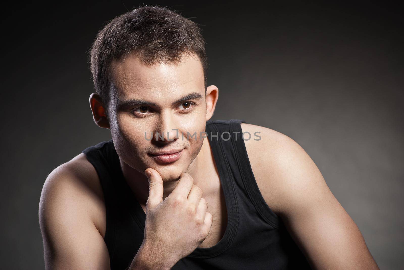 Closeup portrait of a sexy male model on dark grey background