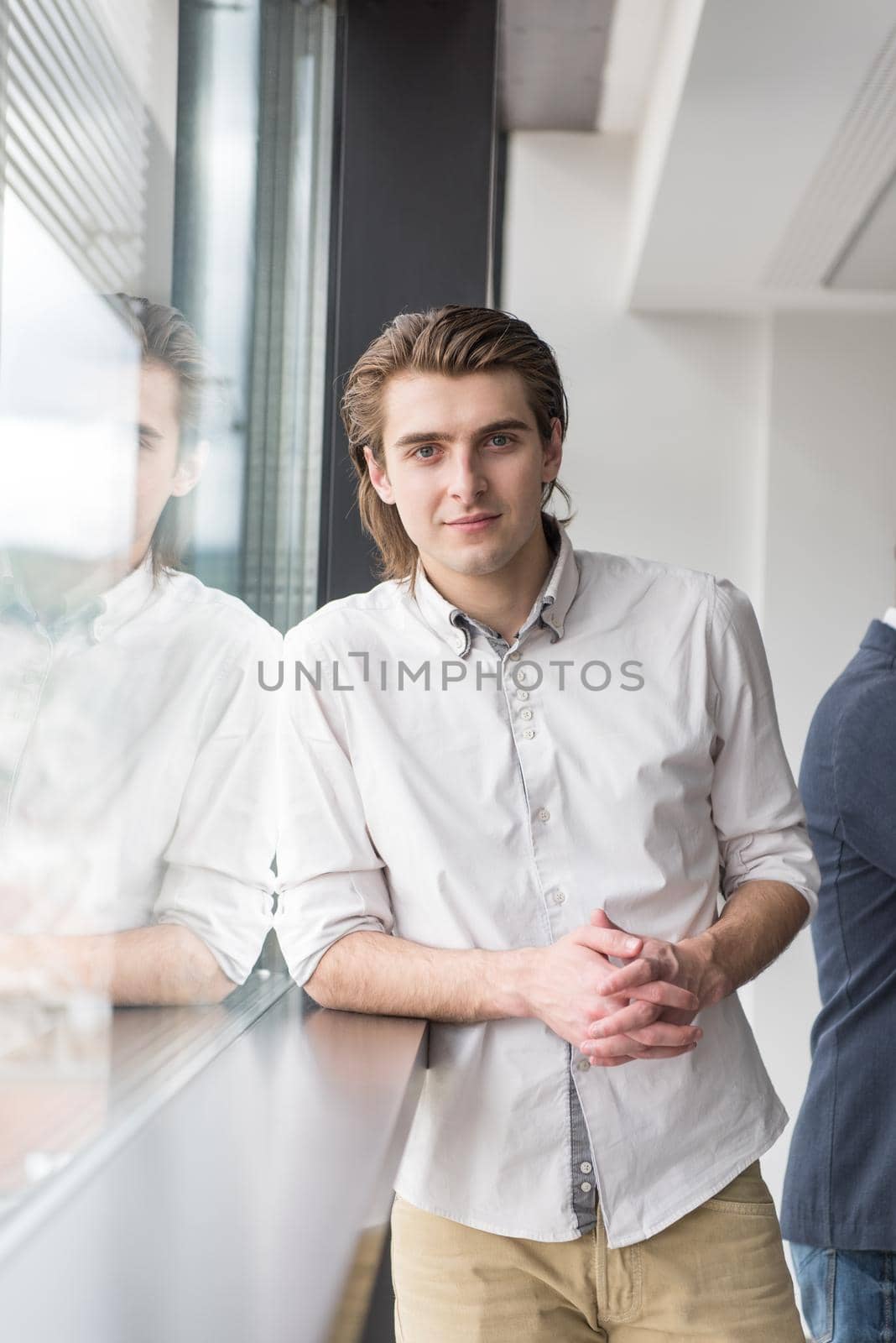 portrait of young businessman at startup office by the window