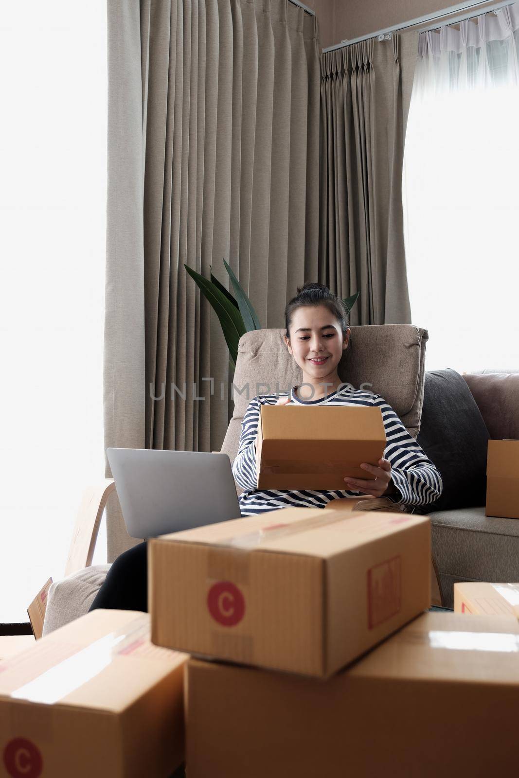 Business Start up SME concept. Young startup entrepreneur small business owner working at home, packaging and delivery situation. Women, owener of small business packing product in boxes.