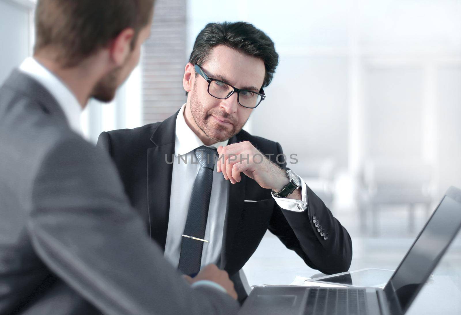 two businessmen discussing information from a laptop.business concept