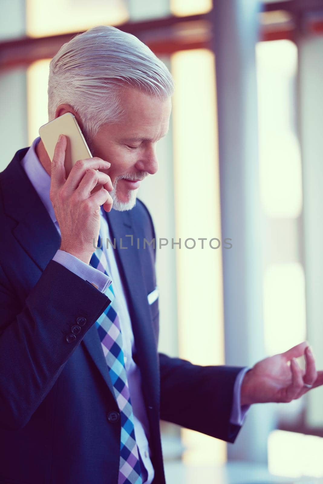 senior business man talk on mobile phone  at modern bright office interior