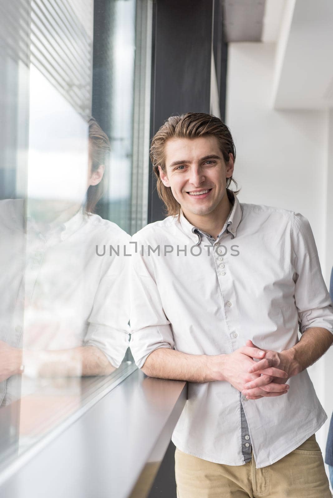 portrait of young businessman at startup office by the window