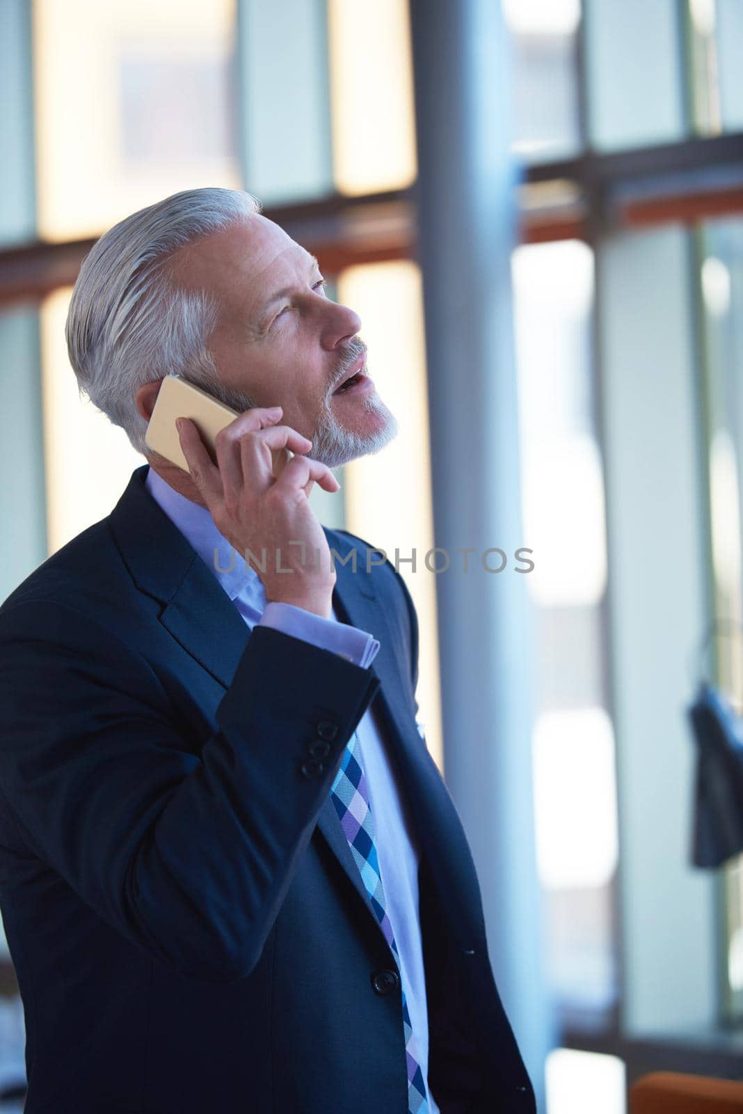 senior business man talk on mobile phone  at modern bright office interior