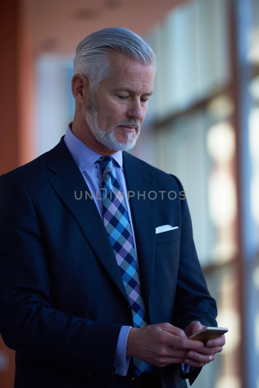 senior business man talk on mobile phone  at modern bright office interior