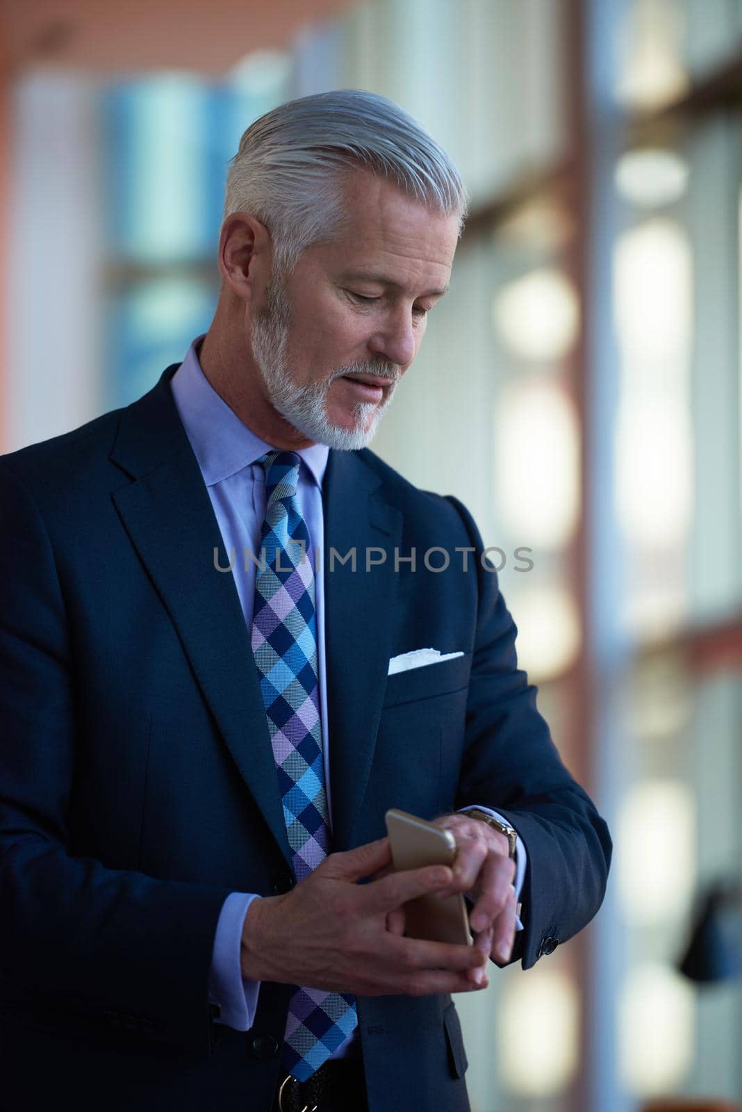 senior business man talk on mobile phone  at modern bright office interior