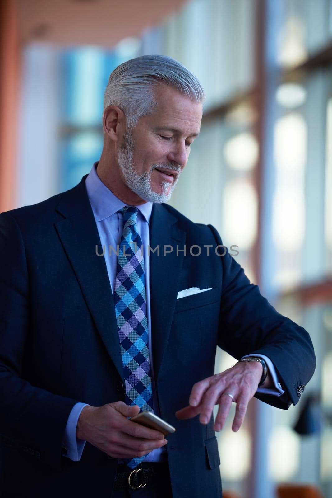 senior business man talk on mobile phone  at modern bright office interior