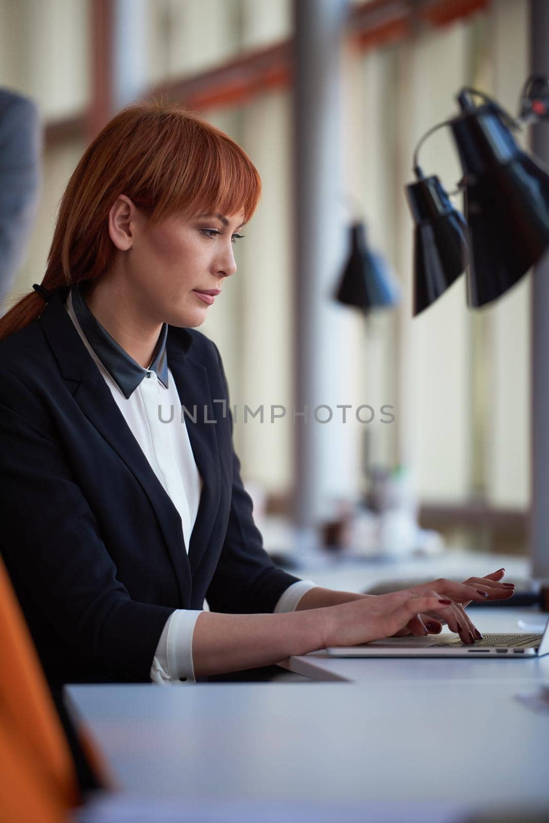 business woman working on computer at office by dotshock