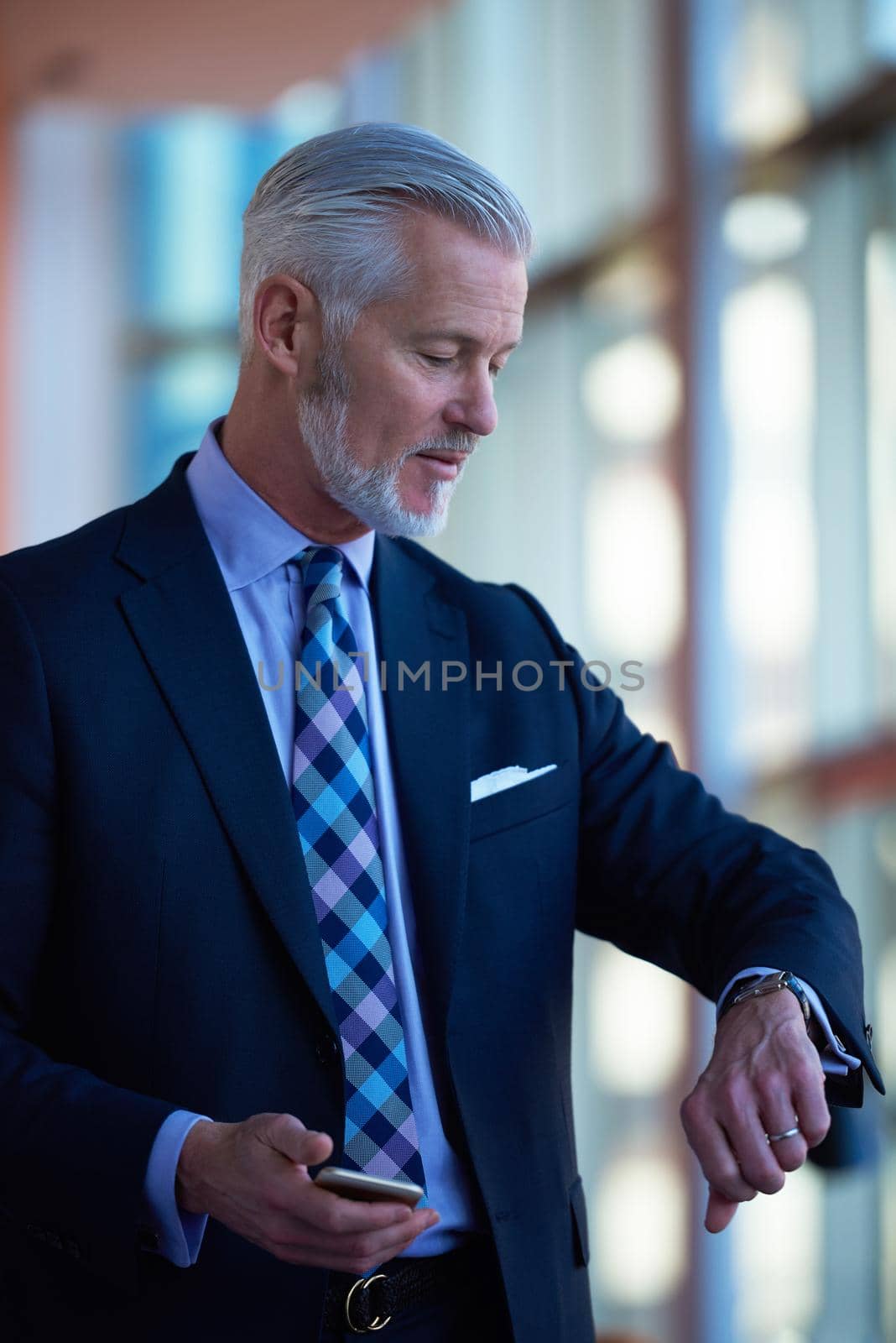 senior business man talk on mobile phone  at modern bright office interior