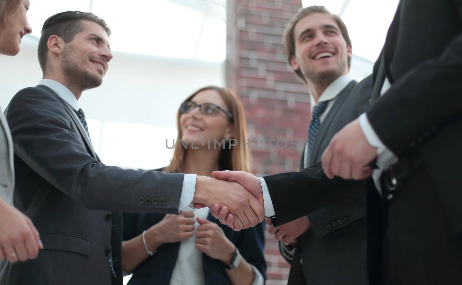 Happy businesswomen shaking hands in office