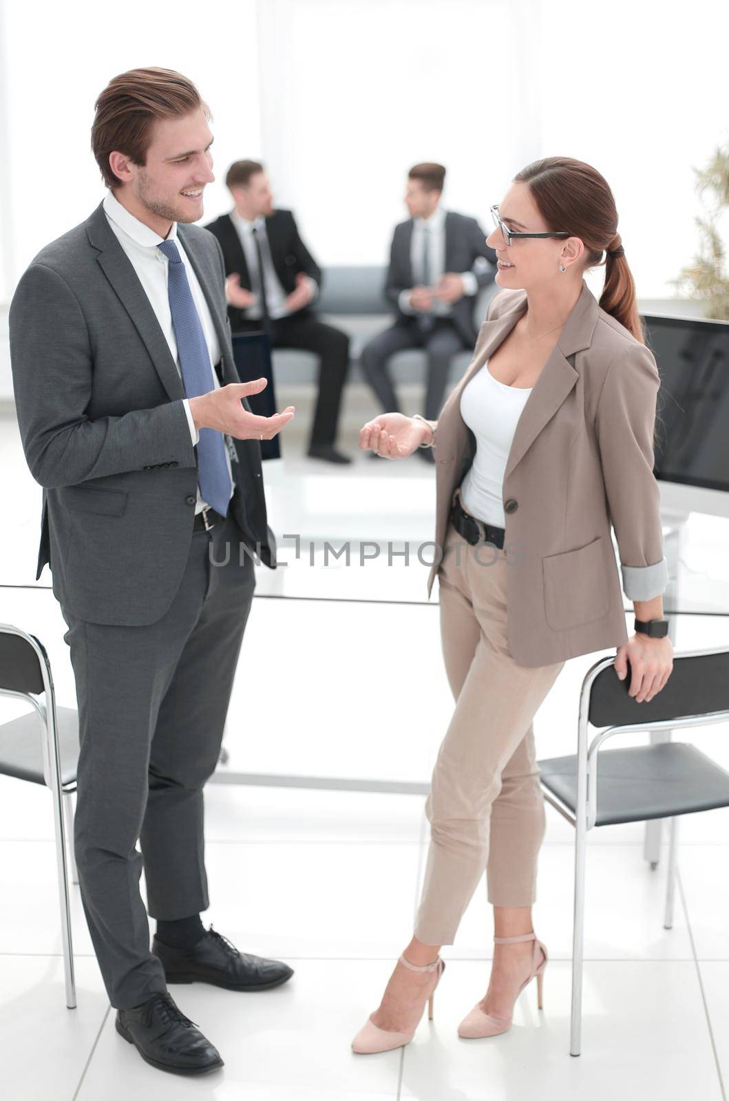 businessman and business woman standing in office talking with the receptionist.business concep