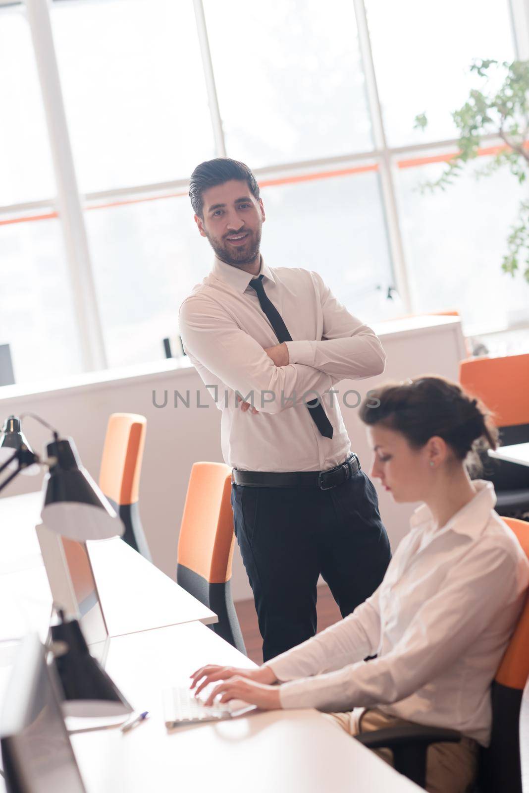 business woman working on desktop computer at modern startup office, people group in background