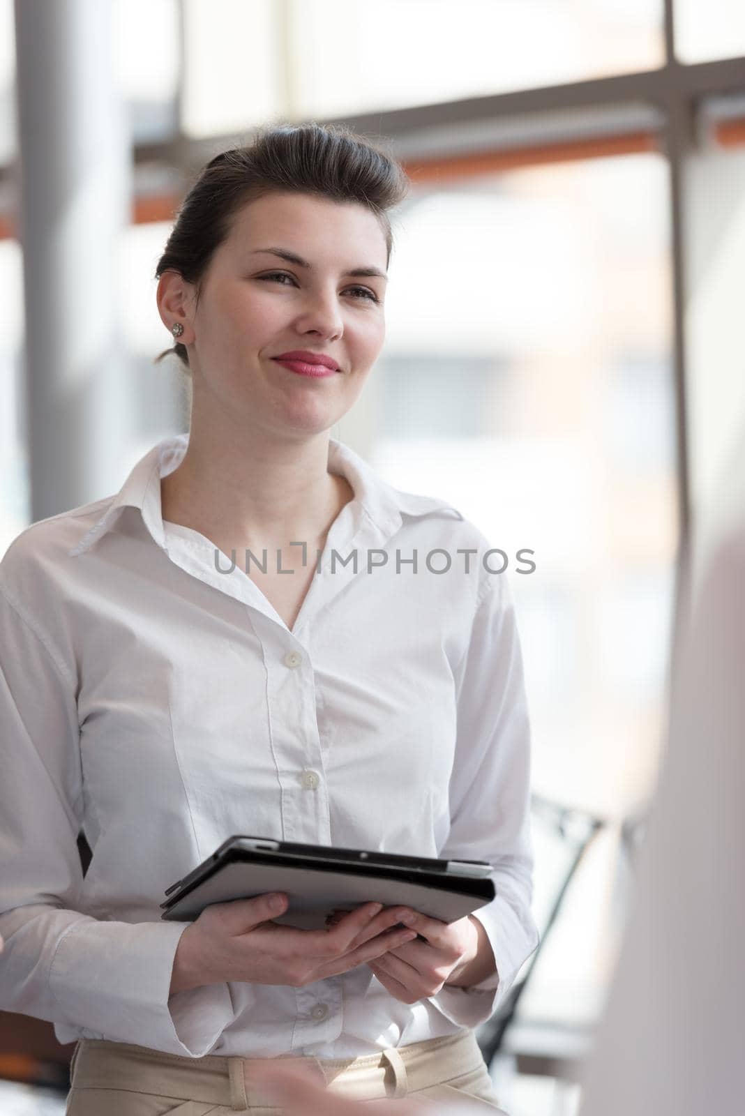 portrait of young business woman with tablet computer at modern office interior