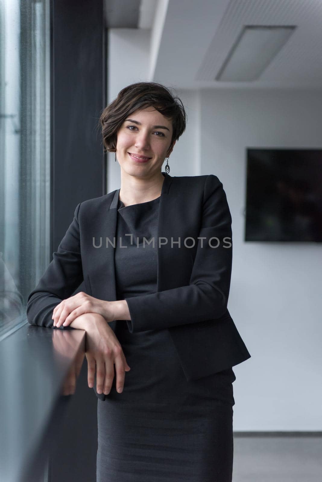 Portrait Of Successful Businesswoman by the window Entrepreneur At Busy startup Office