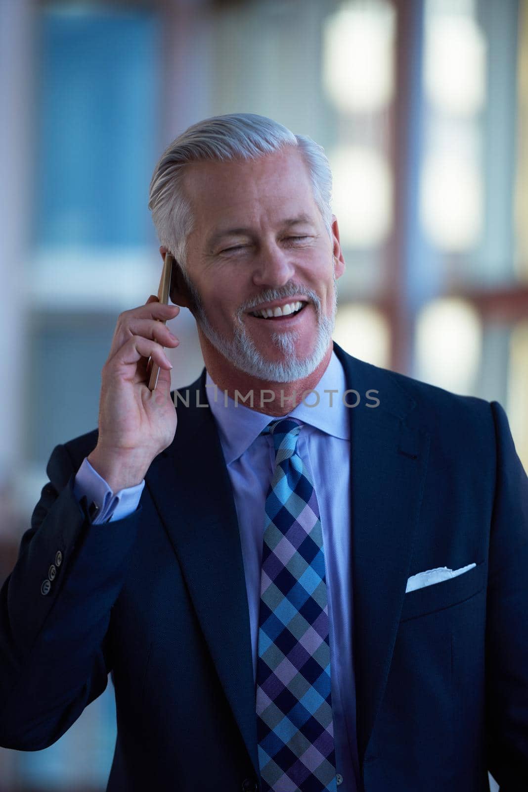 senior business man talk on mobile phone  at modern bright office interior