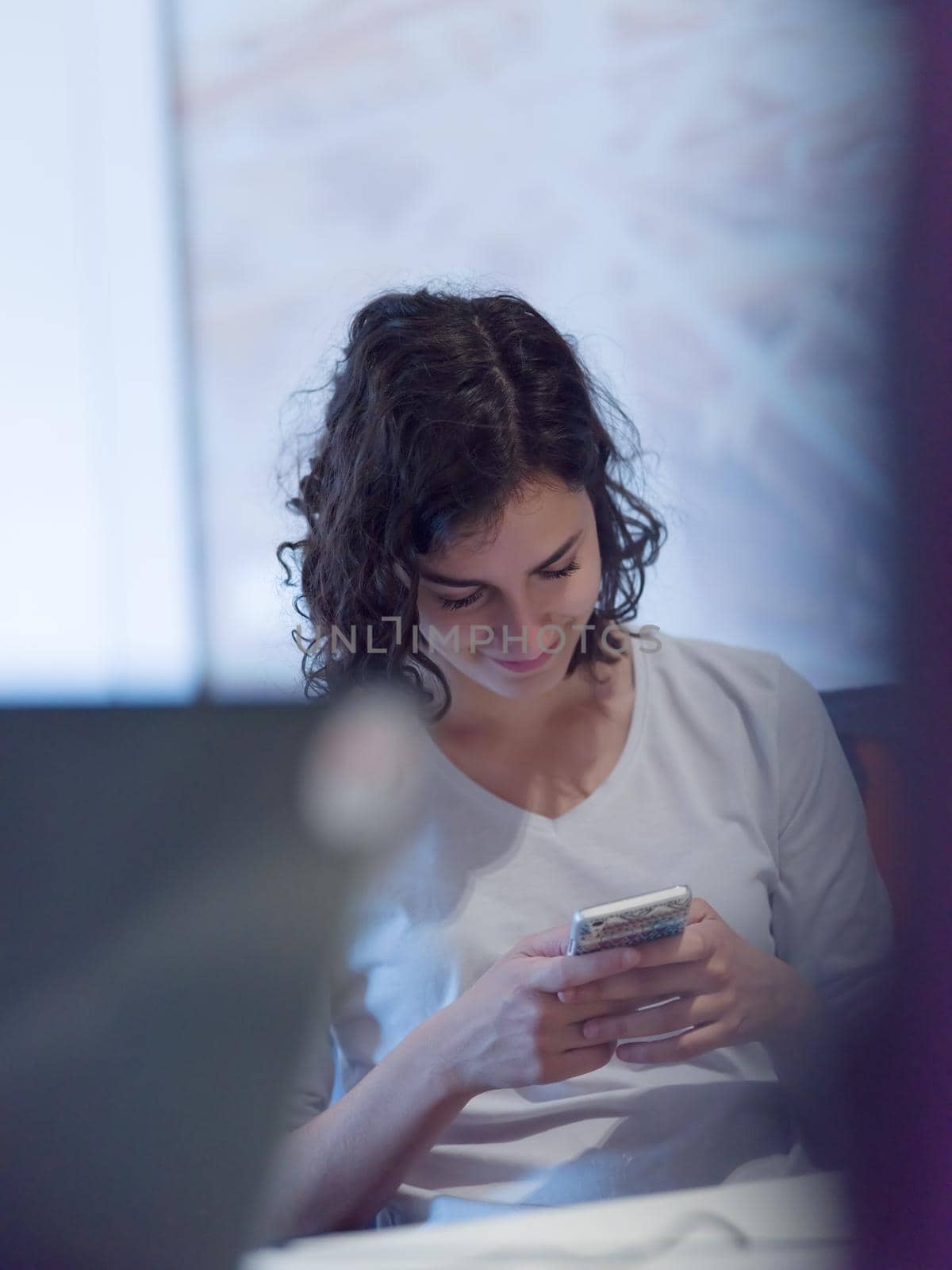 Businesswoman typing on phone while browsing internet at work in office