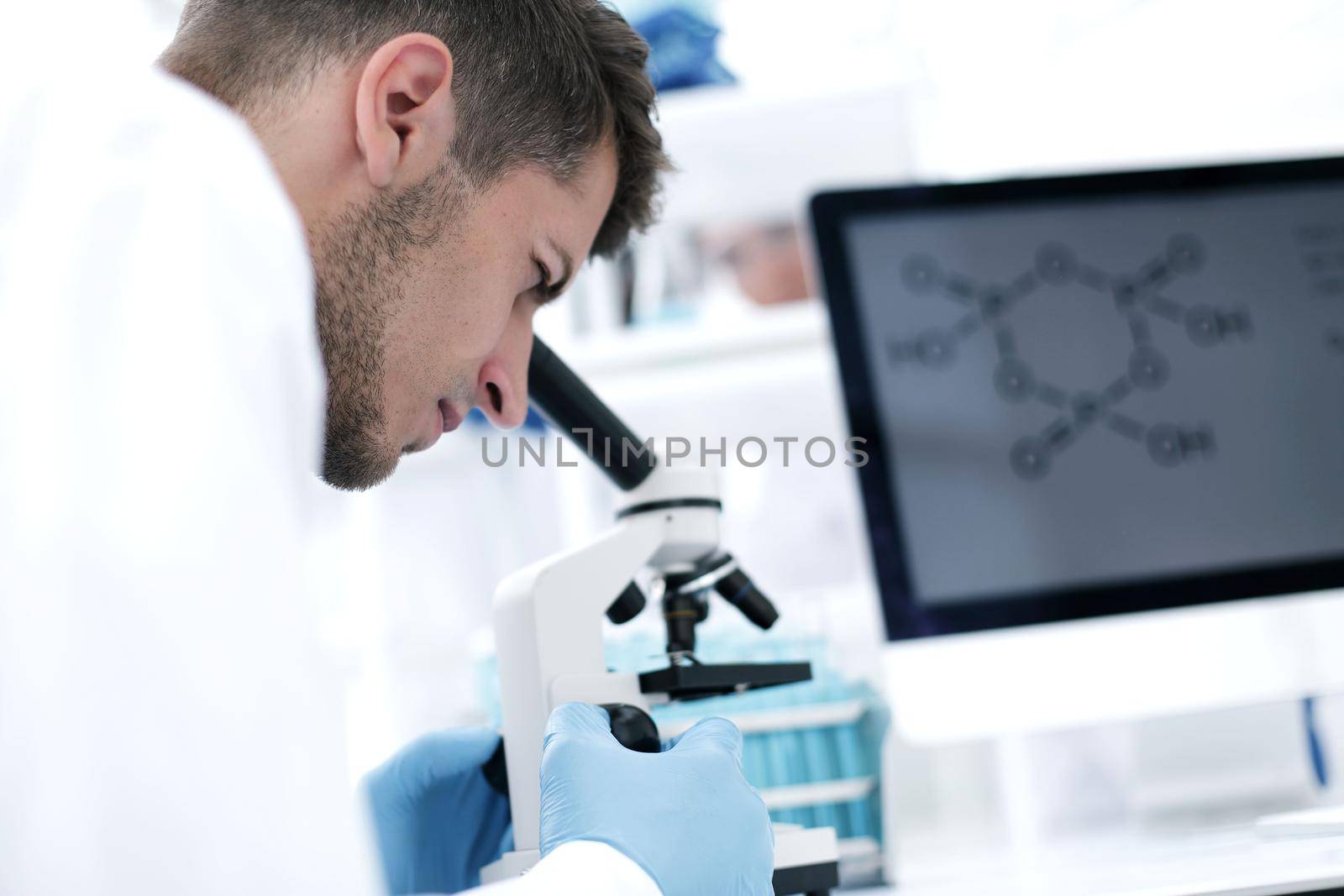 close up.Scientist looking through a microscope in a laboratory