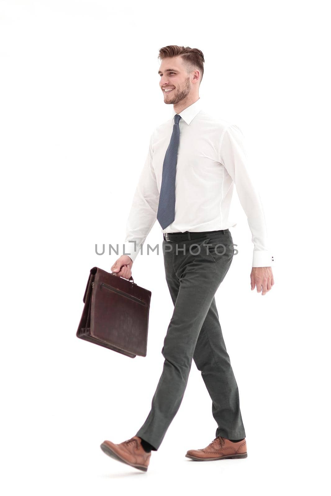 side view.smiling businessman confidently steps forward.isolated on white