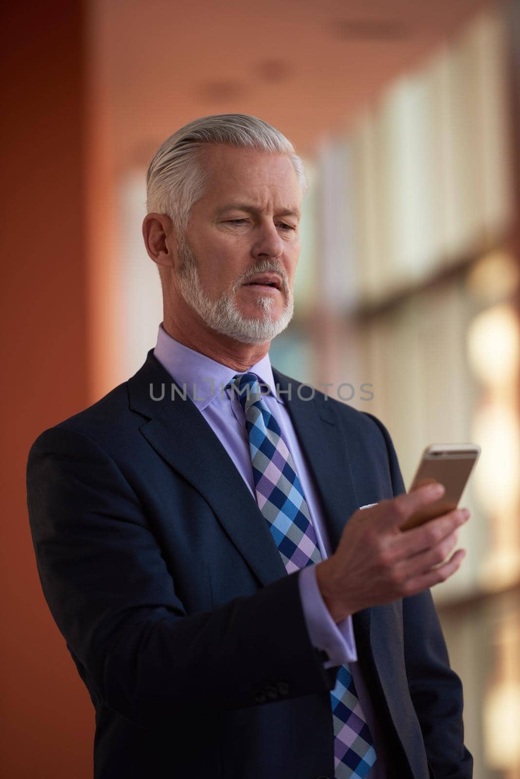 senior business man talk on mobile phone  at modern bright office interior