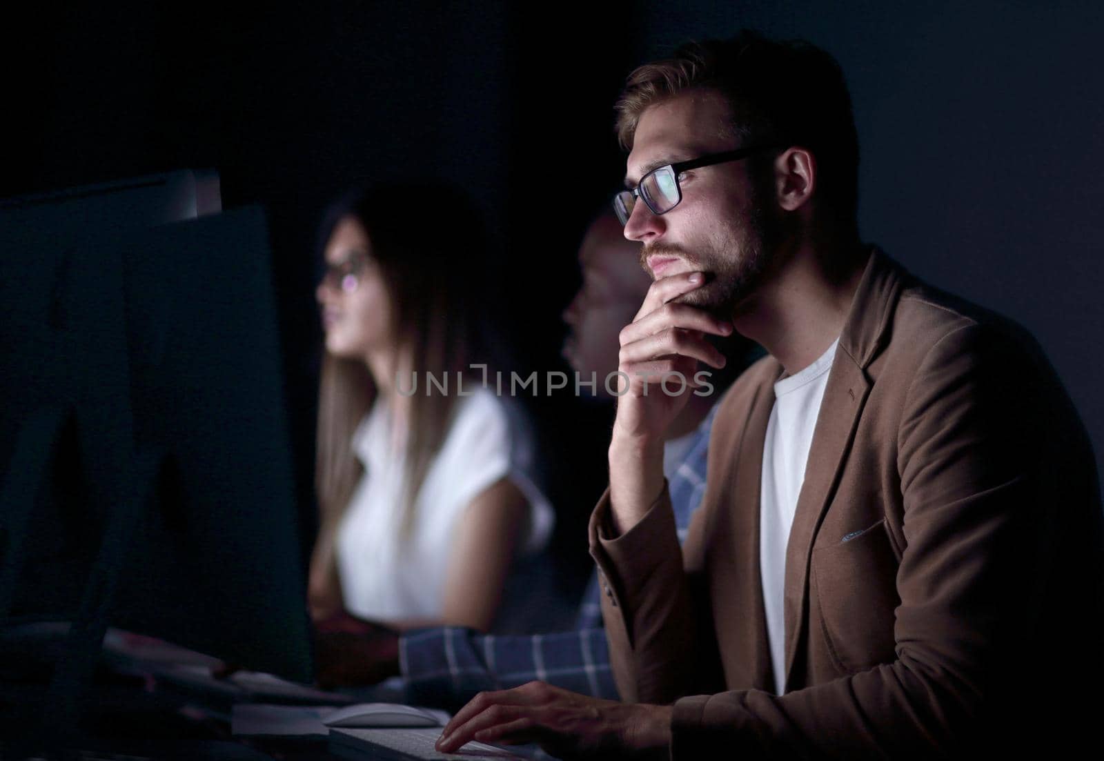 close up.serious businessman sitting at his Desk .photo on black background