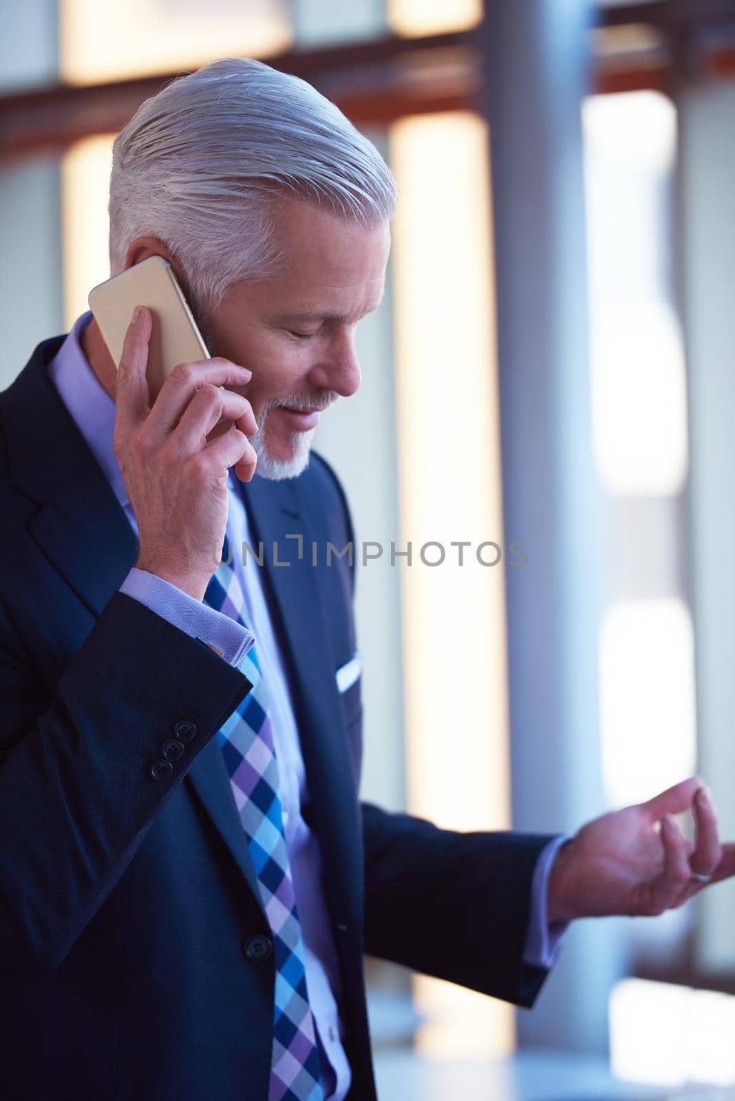 senior business man talk on mobile phone  at modern bright office interior